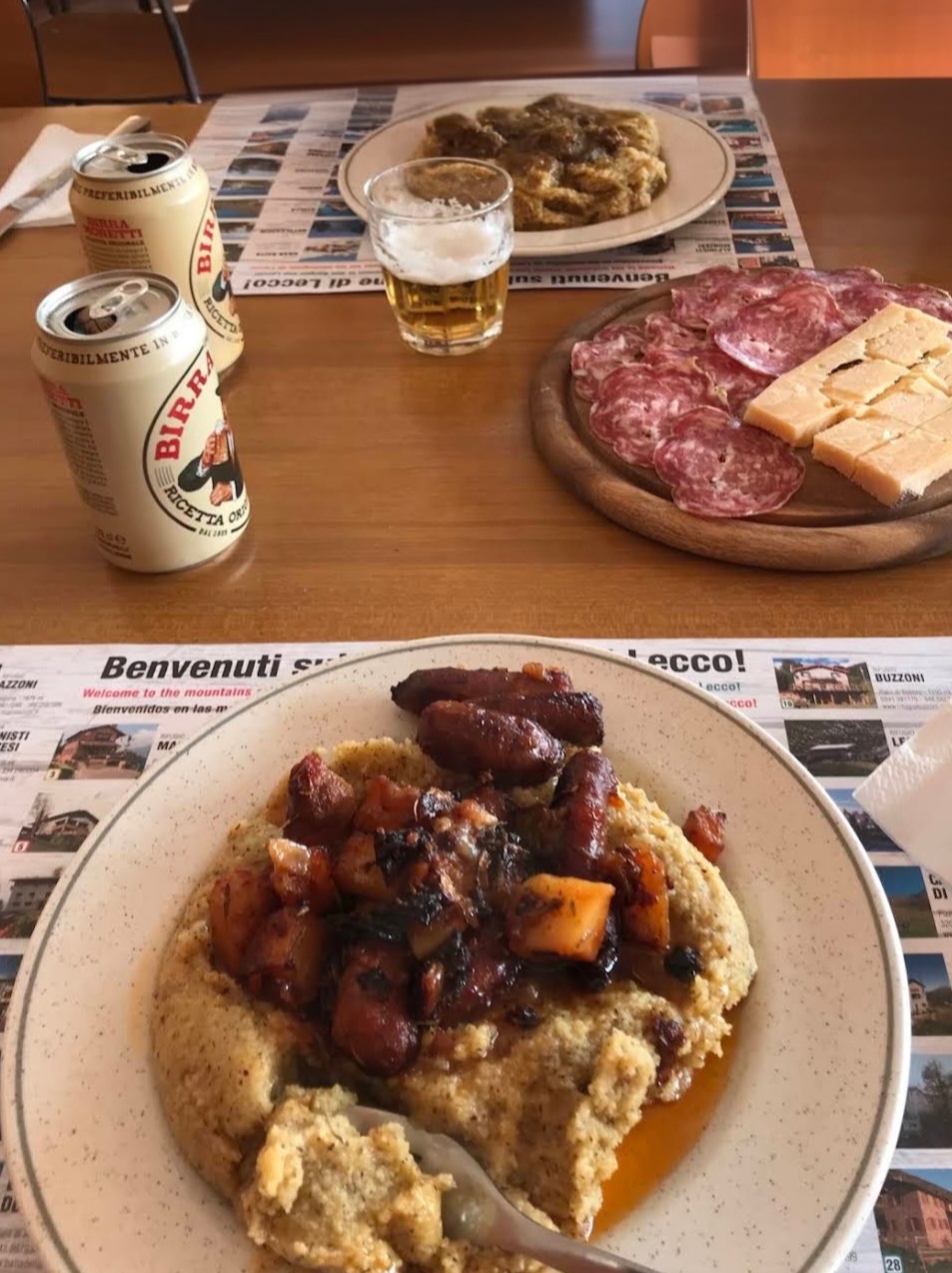 Polenta con salsiccia, tagliere di salumi e formaggi del territorio serviti con birra artigianale